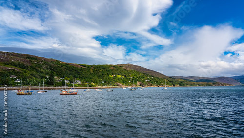 Coastal landscape with fishing and pleasure boats docked near the coast in Ullapool, Scotland.