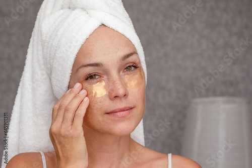Bild auf Leinwand Portrait of middle aged woman of 40s after shower with towel on head with gold p
