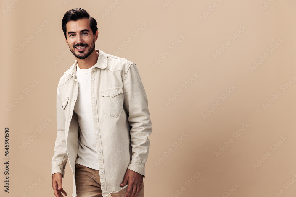 Stylish man smile on a beige background in a white t-shirt and business jacket, flying clothes hero, fashionable clothing style, copy space, space for text