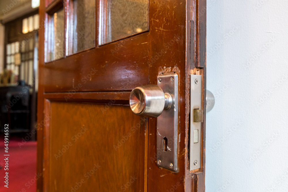 Obraz premium 古い木の扉の鍵付きドアノブ