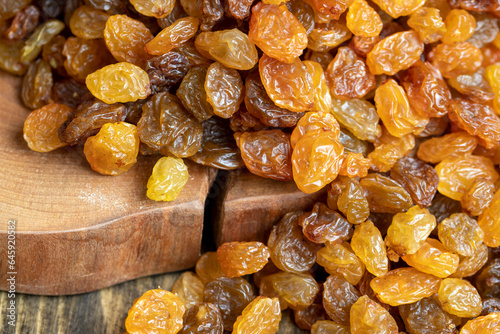 Dried yellow golden raisins on a board