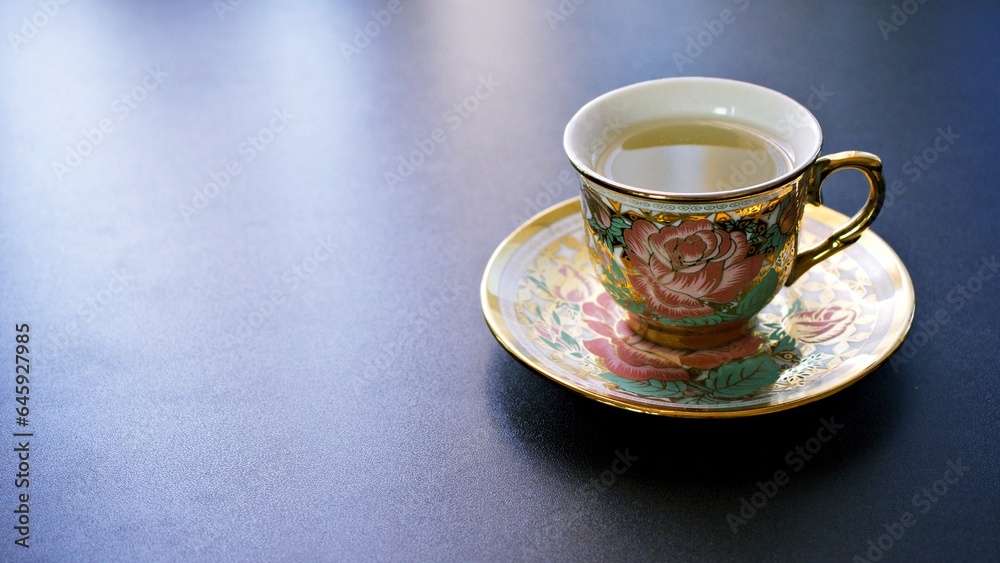 Fototapeta premium Romantic tea time banner with vintage pink rose porcelain tea cup on a dark gray background ,copy space