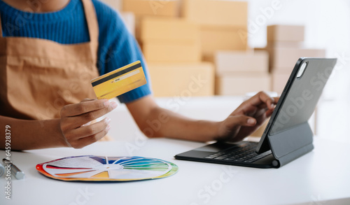 Woman Hand using tablet ,laptop, and holding mobile phone with credit card online banking payment communication network, internet application virtual icon .