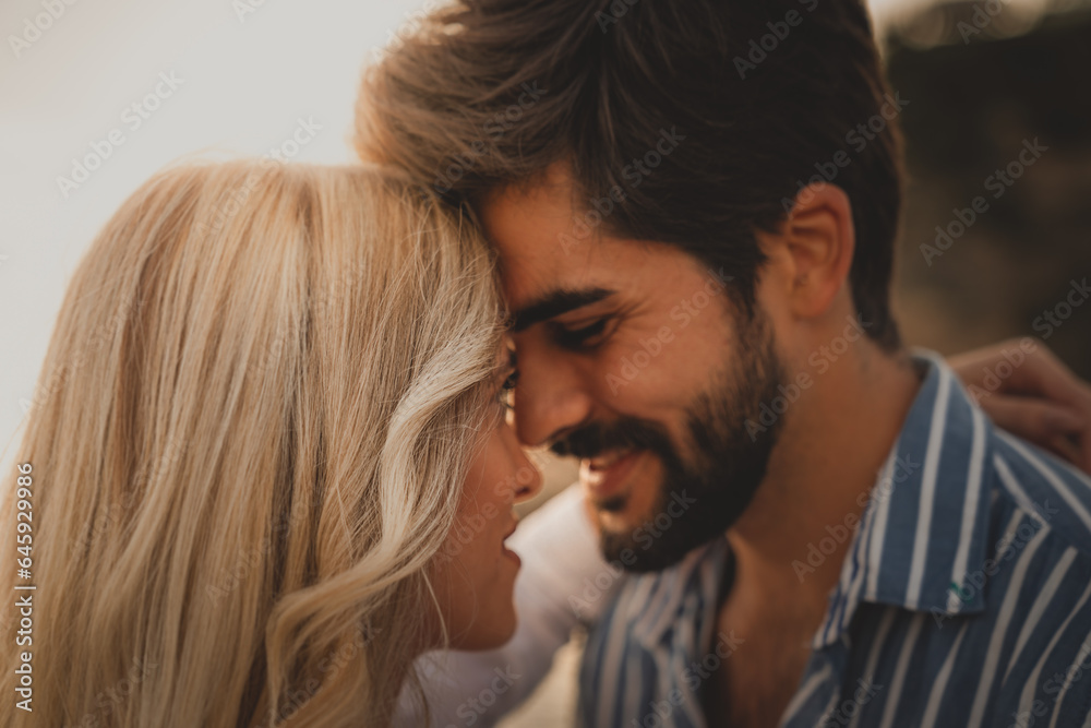 Close-up photo of a lovely couple bonding at the beach. Romantic male and female looking each other into eyes during the sunset. Close-up photo of a lovely couple bonding at the beach. Romantic male and female looking each other into eyes during the sunset.