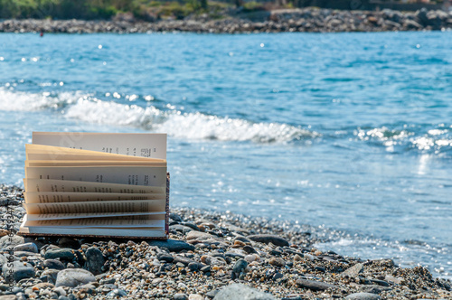 Libro aperto con pagine al vento in riva al mare photo