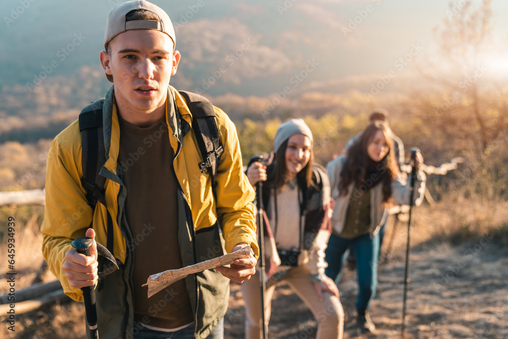 Group of hikers walking in line on a footpath in the mountain, holding ...