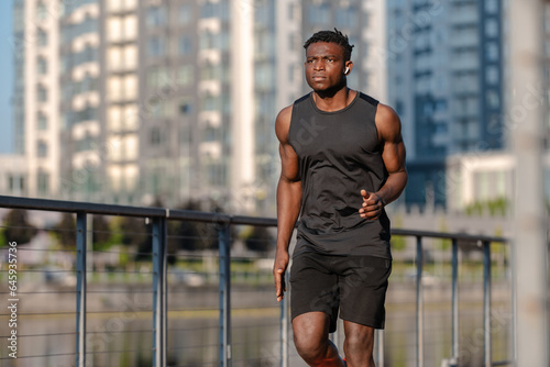 Confident African man in sportswear looking concentrated while jogging outdoors