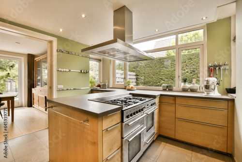 a modern kitchen with wood cabinets and stainless steel range hoods in the center of the room is an outdoor dining area