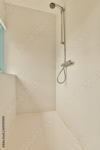 a bathroom with white tiles on the walls and shower head mounted to the wall next to the bathtub is blue