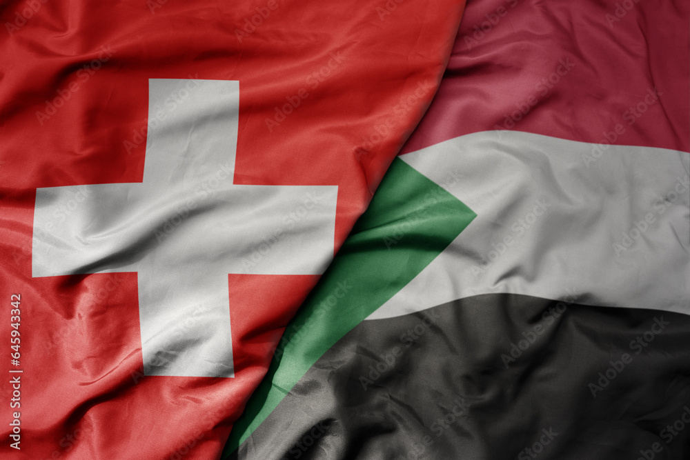 big waving national colorful flag of switzerland and national flag of sudan . big waving national colorful flag of switzerland and national flag of sudan .
