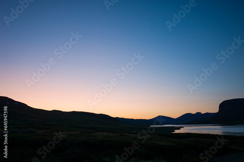 Night sky in twilight in Swedish Lapland arctic summer midnight. Lake Alisjavri on Kungsleden and Nordkalottruta Arctic hiking Trail in northern Sweden