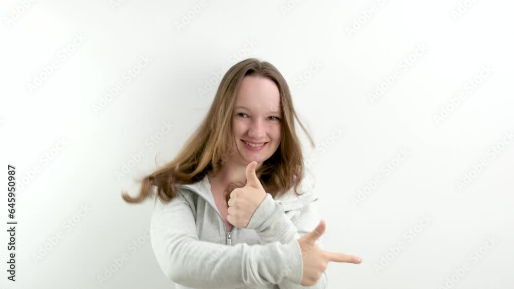 teenage girl cheerfully jumps and shows Finger to the side and the other hand thumbs up approval offer take buy it Good advertising space for text cheerful teenager adolescence. wonderful product teenage girl cheerfully jumps and shows Finger to the side and the other hand thumbs up approval offer take buy it Good advertising space for text cheerful teenager adolescence. wonderful product