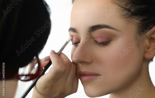 Close-up of wonderful woman making maquillage at professional visagiste. Beautiful model visiting popular professional saloon. Beauty and cosmetics concept