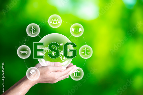 Esg icon in hand on green nature background green energy icon around. Investing in environmental, social, governance or Investing ESG in industry. ESG investment. Green renewable energy concept.