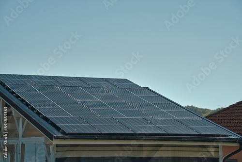 House roof with solar panels installed. The integration of solar technology into the roof tiles highlights the innovative approach to energy generation, offering an alternative source of electricity.