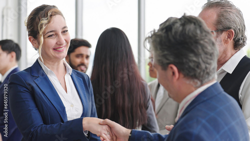 Caucasian man leader introducing woman manager to new team partner at seminar of company. Male leader introducing woman manager shaking hands welcoming newcomer