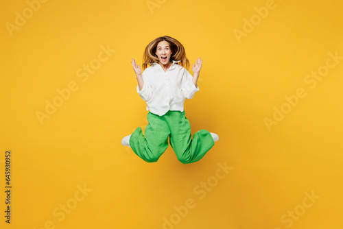 Full body young shocked surpised caucasian happy woman she wears white shirt casual clothes jump high look camera spread hands isolated on plain yellow background studio portrait. Lifestyle concept.