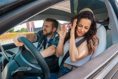Amazed instructor sitting in car and looking straight ahead while lady closing her eyes and screaming. Traffic accident. Driving test, driver courses, exam concept © Nataliya