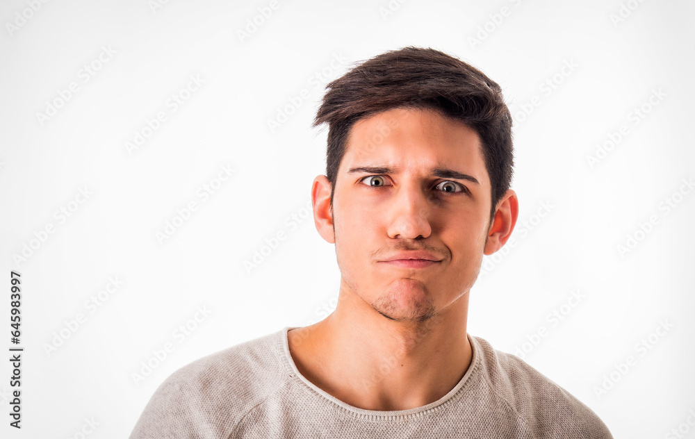 Confused young man looking at camera in studio Confused young man looking at camera in studio