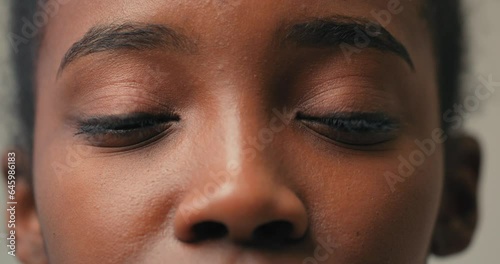 Brown eyes of young African smiling happy woman looking at camera Slow motion. Isolated on white background Studio shot Natural beauty, skin care, beauty Wellbeing, healthy lifestyle and domestic life