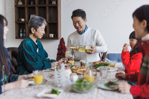 クリスマスホームパーティーで食事をする日本人家族 photo