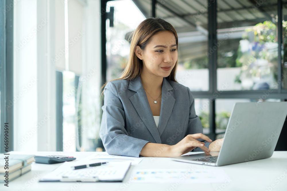Asian businesswoman sit at their desks and calculate financial graphs showing results about their investments, planning a successful business growth process Asian businesswoman sit at their desks and calculate financial graphs showing results about their investments, planning a successful business growth process