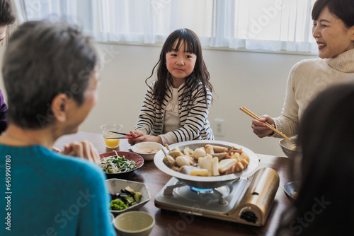 家族とおでんを食べる日本人の女の子