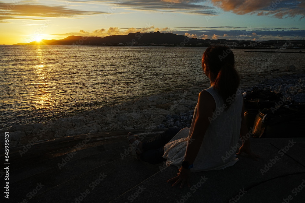 Woman seating in Sunset Image of Agarie Beach in Nago, Okinawa, Japan - 日本 沖縄 名護 東江ビーチに座る女性