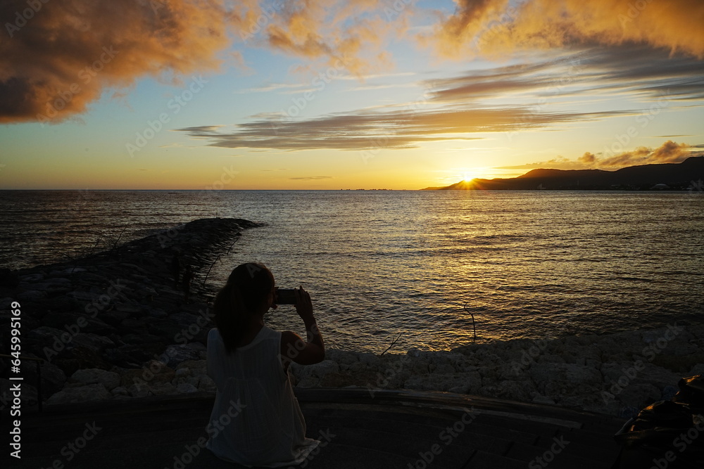Woman seating in Sunset Image of Agarie Beach in Nago, Okinawa, Japan - 日本 沖縄 名護 東江ビーチに座る女性