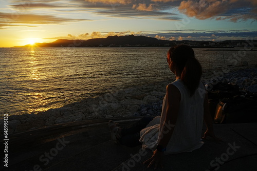 Woman seating in Sunset Image of Agarie Beach in Nago, Okinawa, Japan - 日本 沖縄 名護 東江ビーチに座る女性