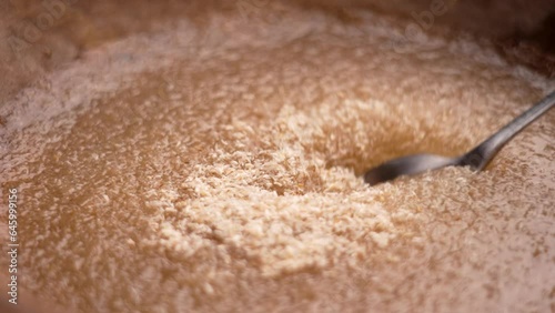 Psyllium husk supplement with water. Mixing with spoon in wooden bowl. Preparation of drinking medicional gel. Dietary fiber. Alternative natural medicine photo