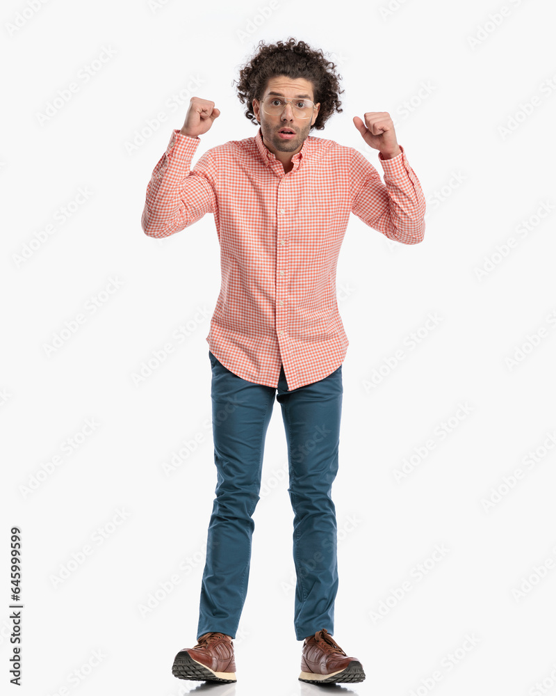 surprised casual man with glasses holding fists up and walking surprised casual man with glasses holding fists up and walking