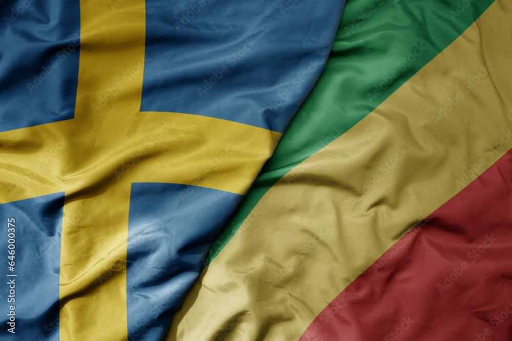 big waving national colorful flag of sweden and national flag of republic of the congo .