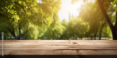 Spring summer beautiful nature background with blurred park trees in sunlight and empty wooden table photo