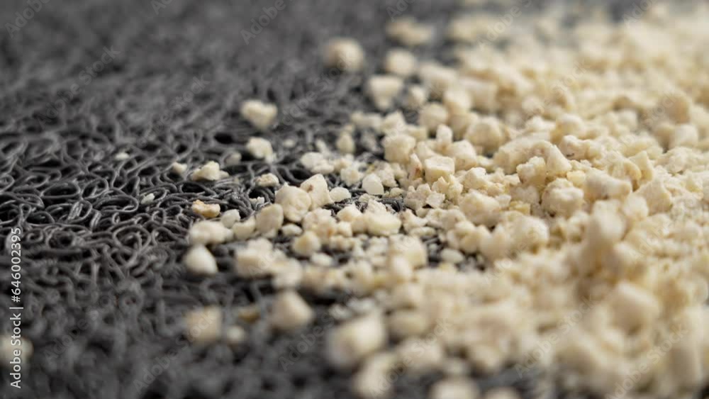 Biodegradable ecological kitten corn litter particles on rubber cat mat. Rotation Biodegradable ecological kitten corn litter particles on rubber cat mat. Rotation