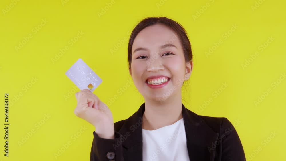 Portrait beautiful young asian business woman hold credit card or debit card for shopping payment and transaction with financial isolated yellow background, businesswoman showing atm, finance concept. Portrait beautiful young asian business woman hold credit card or debit card for shopping payment and transaction with financial isolated yellow background, businesswoman showing atm, finance concept.