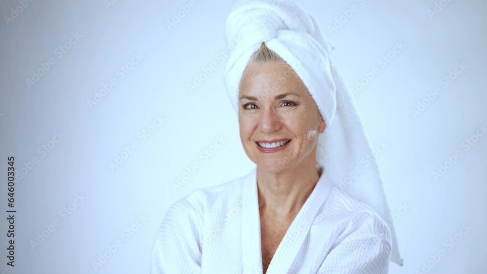 Portrait of happy smiling attractive middle aged woman wearing bathrobe and white towel looking at camera. Advertising body care spa concept. Portrait of happy smiling attractive middle aged woman wearing bathrobe and white towel looking at camera. Advertising body care spa concept.