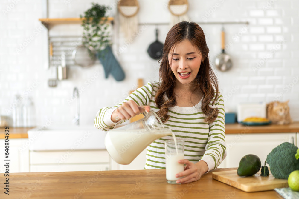 Portrait of beauty healthy asian woman smiling and having protein breakfast drinking and hold glasses of milk of fresh milk, nutrition,calcium and vitamin,dairy product in kitchen at home.Diet concept Portrait of beauty healthy asian woman smiling and having protein breakfast drinking and hold glasses of milk of fresh milk, nutrition,calcium and vitamin,dairy product in kitchen at home.Diet concept