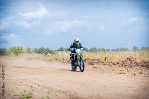 Enduro bike racer driving on dirt motocross dust track
