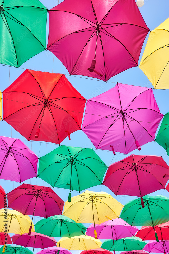 Hanging colorful umbrellas against the blue sky.