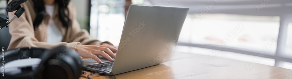 Female podcaster use laptop to typing text and working to making audio podcast in broadcast studio Female podcaster use laptop to typing text and working to making audio podcast in broadcast studio