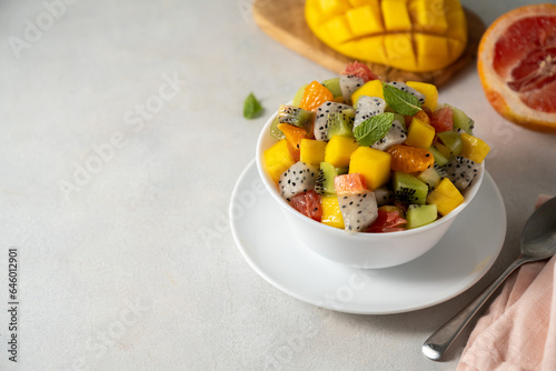 Exotic fruit salad with fresh mango, dragon fruit, grapefruit, kiwi. Copy space