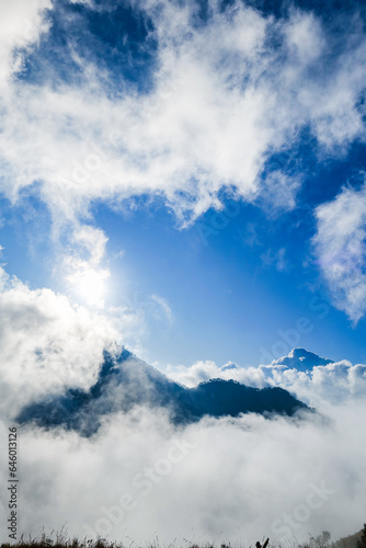 mountain peak covered by sea of cloud with blue sky in the morning at Mount Rinjani, Lombok, Indonesia. Atmospheric mountain nature photo for adventure, trekking, mountaineering concept