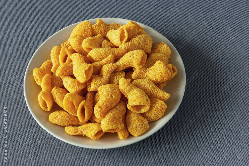 yellow cone-shaped snack crackers in a plate on a tablecloth yellow cone-shaped snack crackers in a plate on a tablecloth