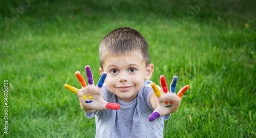 Children s hands in the colors of summer  a smile on the boy s palm