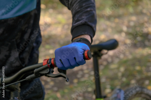 Cyclist's hand in a blue glove close up.Cycling.Hand on the handlebars of a bicycle