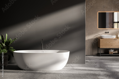 minimalist bathroom interior  concrete floor and gray and beige walls  bathroom cabinet  bathtub.