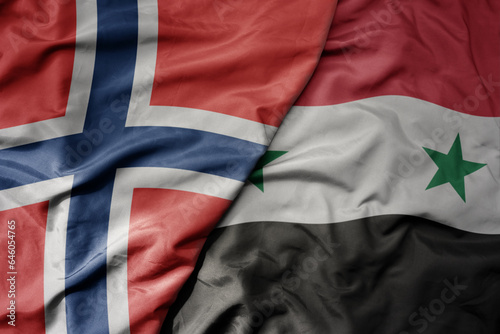 big waving national colorful flag of norway and national flag of syria .