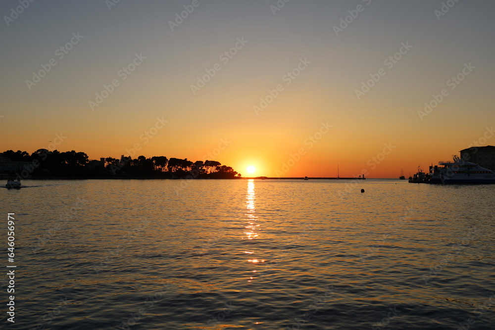 Sunset on the Adriatic sea in Porec, Istria, Croatia, Europe. Beautiful sunset by the Adria sea, The sun is setting over the sea, Porec
