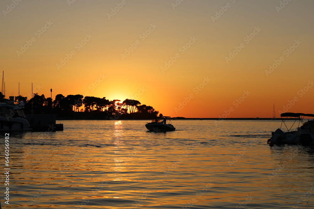 Sunset with boat silhouettes on the Adriatic sea in Porec, Istria, Croatia, Europe. Beautiful sunset by the Adria sea, The sun is setting over the sea, Porec Sunset with boat silhouettes on the Adriatic sea in Porec, Istria, Croatia, Europe. Beautiful sunset by the Adria sea, The sun is setting over the sea, Porec